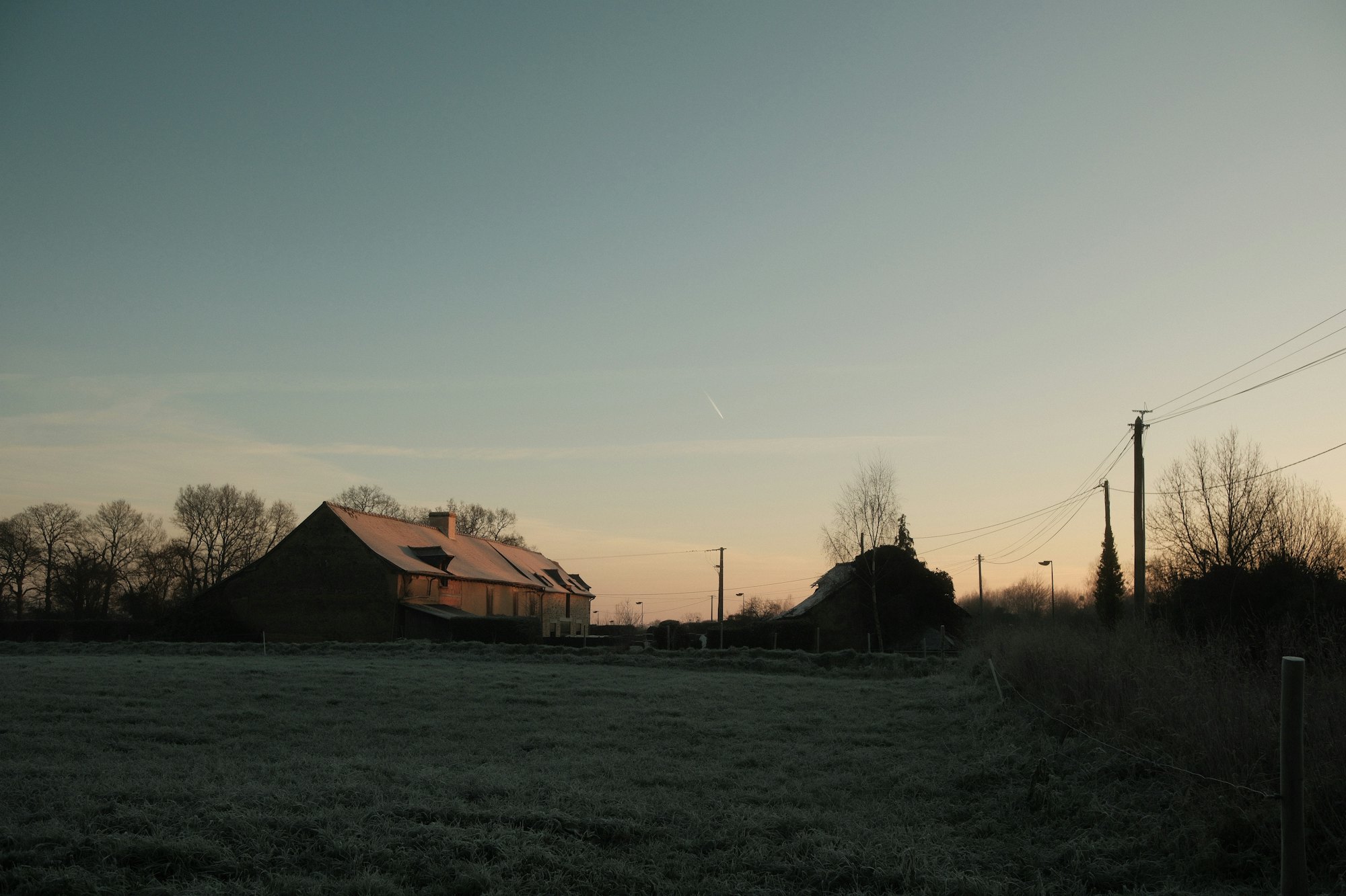 Farm buildings at sunrise over a frosted field