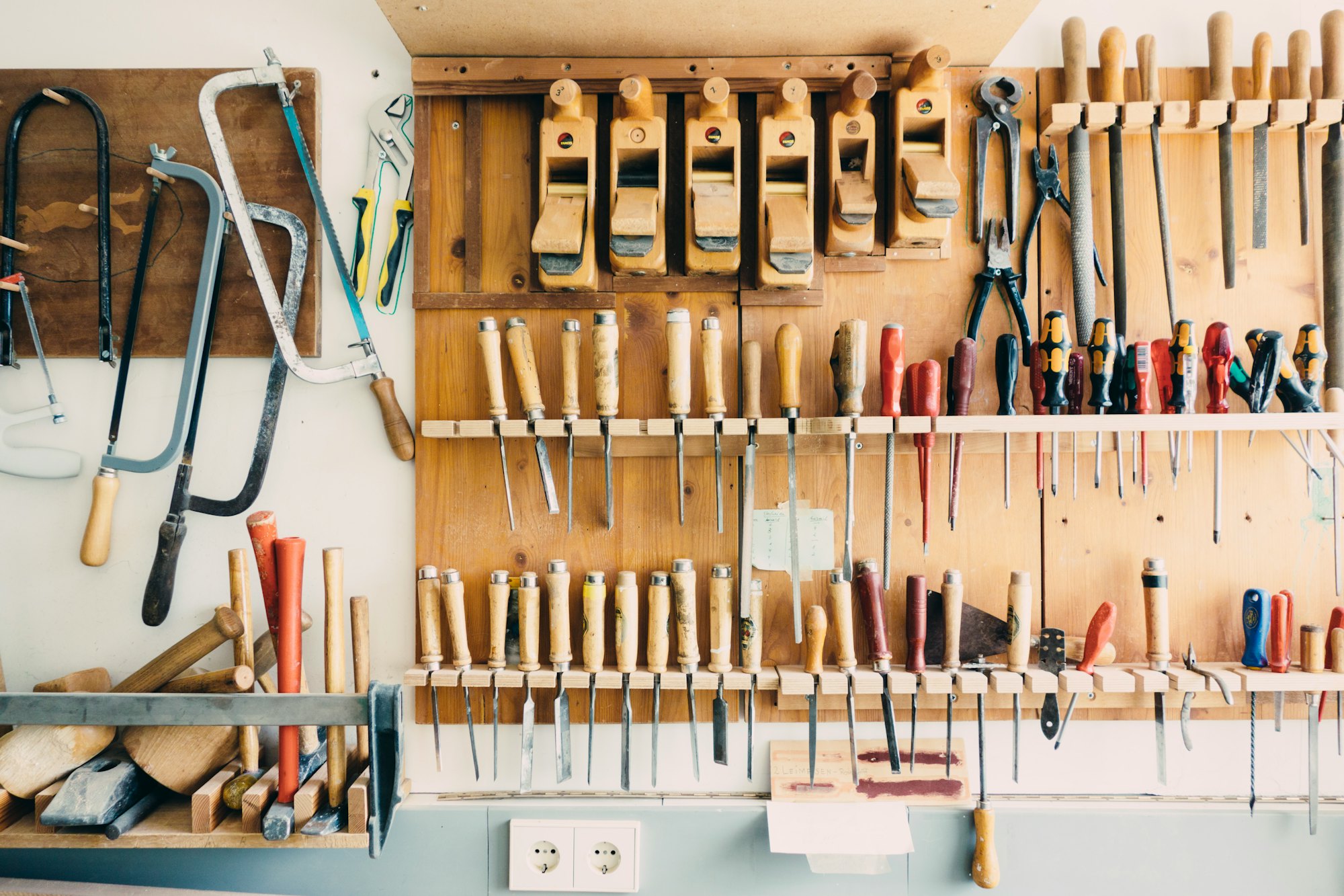 Hand tools hung on a workshop wall